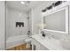 Modern bathroom featuring white cabinets, marble countertops, a shower/tub combo, and a backlit mirror at 9900 Summer Ash Ct # 103, Las Vegas, NV 89134