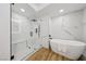 Bright bathroom featuring a glass shower, soaking tub, and marble-style wall tiles at 9900 Summer Ash Ct # 103, Las Vegas, NV 89134