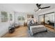 Bright bedroom featuring wood floors, double-hung windows, modern decor, and mirrored closet doors at 9900 Summer Ash Ct # 103, Las Vegas, NV 89134