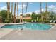 Sparkling community pool surrounded by lush landscaping, lounge chairs, and shade umbrellas at 9900 Summer Ash Ct # 103, Las Vegas, NV 89134