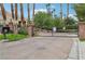 Gated entrance to a beautiful community featuring lush landscaping, palm trees, and well maintained lawns at 9900 Summer Ash Ct # 103, Las Vegas, NV 89134