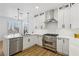 Bright kitchen with white cabinets, stainless steel appliances, quartz countertops and modern pendant lighting at 9900 Summer Ash Ct # 103, Las Vegas, NV 89134