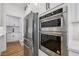 Modern kitchen featuring stainless steel appliances, double ovens, refrigerator, and sleek white cabinetry at 9900 Summer Ash Ct # 103, Las Vegas, NV 89134