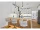 Modern kitchen with white cabinets, quartz countertops, wood floors, and stylish barstool seating at the island at 9900 Summer Ash Ct # 103, Las Vegas, NV 89134