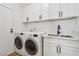 Functional laundry room with modern washer and dryer, white cabinets, and granite countertop at 9900 Summer Ash Ct # 103, Las Vegas, NV 89134