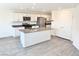 Modern kitchen with stainless steel appliances, white cabinets, gray countertops, and a center island at 10434 Luna Mezzo St Ave # Lot 188, Las Vegas, NV 89141