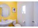 Charming powder room boasts bright yellow accent wall and modern fixtures at 10434 Rose Palisade St, Las Vegas, NV 89141