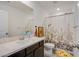 Bright bathroom with a marble countertop vanity, toilet, and floral shower curtain at 10434 Rose Palisade St, Las Vegas, NV 89141