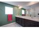 Well-lit bathroom featuring a large vanity with dual sinks and a glass-enclosed shower at 10434 Rose Palisade St, Las Vegas, NV 89141