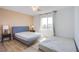 Bright bedroom with light wood floors, a queen bed, and a sunlit window at 10434 Rose Palisade St, Las Vegas, NV 89141