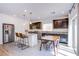 Well-lit kitchen with stainless steel appliances, breakfast bar, and adjacent dining area featuring dark cabinetry and modern lighting at 10434 Rose Palisade St, Las Vegas, NV 89141
