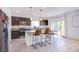 Modern kitchen with stainless steel appliances, sleek dark cabinetry, breakfast bar and a adjacent dining area at 10434 Rose Palisade St, Las Vegas, NV 89141