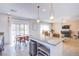 Open floor plan with kitchen island featuring pendant lights and dining table with view of the living room at 10434 Rose Palisade St, Las Vegas, NV 89141