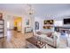 Bright living room featuring hardwood floors, elegant chandelier, and a seamless transition into a modern kitchen with bar seating at 10434 Rose Palisade St, Las Vegas, NV 89141