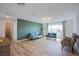 Spacious living area with hardwood floors, accented by a sage green wall, with stylish seating at 10434 Rose Palisade St, Las Vegas, NV 89141