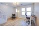 A modern home office featuring light wood floors, a modern chair and bright, natural lighting at 10434 Rose Palisade St, Las Vegas, NV 89141