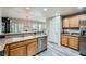 Well-lit kitchen with stainless steel appliances, wood cabinets, and granite countertops at 10809 Garden Mist Dr # 1042, Las Vegas, NV 89135