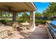 Covered outdoor dining area featuring a built-in grill and comfortable seating amidst lush landscaping at 10809 Garden Mist Dr # 1042, Las Vegas, NV 89135