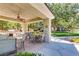Outdoor patio area with multiple tables, chairs, grill, ceiling fan and beautiful green space at 10809 Garden Mist Dr # 1042, Las Vegas, NV 89135