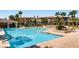 Inviting community pool area with clear blue water, lounge chairs and tropical palm trees at 10809 Garden Mist Dr # 1042, Las Vegas, NV 89135