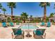 Resort-style community pool with lounge chairs and a serene water feature surrounded by palm trees at 10809 Garden Mist Dr # 1042, Las Vegas, NV 89135