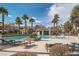Beautiful pool area with palm trees, lounge chairs, and clear blue water for relaxation at 10809 Garden Mist Dr # 1042, Las Vegas, NV 89135