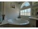 Bright bathroom with a soaking tub and decorative glass block window at 10949 Fintry Hills St, Las Vegas, NV 89141