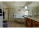 Main bathroom with a large bathtub and a glass-door shower at 10949 Fintry Hills St, Las Vegas, NV 89141