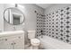 Updated bathroom features a modern vanity, toilet, and tub-shower combo with decorative tile at 1407 Dorothy Ave # 2, Las Vegas, NV 89119