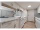 Bright kitchen features white cabinets, countertops, and appliances plus an eat-in counter with a view into the living area at 1407 Dorothy Ave # 2, Las Vegas, NV 89119