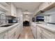 Galley kitchen features white cabinets, countertops, and appliances plus a view into the adjacent dining and living areas at 1407 Dorothy Ave # 2, Las Vegas, NV 89119