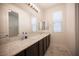 The bathroom features double sinks with granite countertops and large mirrors at 1617 Meadow Bluffs Ave, Henderson, NV 89014