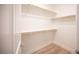 Spacious walk-in closet with wooden rods, white shelving, and wood-look floors provides ample storage at 1617 Meadow Bluffs Ave, Henderson, NV 89014