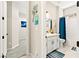 Bright bathroom features a white vanity, quartz countertop, and a bathtub with a blue shower curtain at 163 Caraset Ln, Henderson, NV 89011