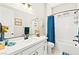 Bright bathroom featuring a white vanity, quartz countertop, and a bathtub with a blue shower curtain at 163 Caraset Ln, Henderson, NV 89011