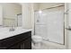 Well-lit bathroom with a glass door shower, white toilet and dark brown vanity at 1633 Dornie Ave, North Las Vegas, NV 89084