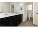 Elegant bathroom featuring dual mirrors, dark cabinets, tiled floor and ample lighting at 1633 Dornie Ave, North Las Vegas, NV 89084