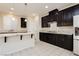 Modern kitchen featuring dark cabinets, granite countertops, and stainless appliances at 1633 Dornie Ave, North Las Vegas, NV 89084