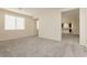 Bright living room featuring neutral walls, plush carpet, and natural light from the window at 1633 Dornie Ave, North Las Vegas, NV 89084