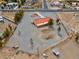 Large lot aerial view showcasing a single-story house with a bright red roof, surrounded by an extensive gravel-covered yard at 1800 Red Rock Dr, Pahrump, NV 89048