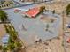 Aerial view of property featuring a red-roofed house with ample yard space, partially fenced and with additional outbuildings at 1800 Red Rock Dr, Pahrump, NV 89048