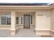 Home entrance showcases a decorative front door, neutral stucco, and manicured landscaping at 1800 Red Rock Dr, Pahrump, NV 89048