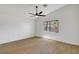 Bright bedroom features wood-look flooring, ceiling fan, neutral walls, and a window with a view at 2050 N Los Feliz St # 171, Las Vegas, NV 89156