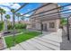 Backyard features synthetic grass, patio, pergola, desert landscaping, and heater with lounge chairs at 21 Rue De Degas, Henderson, NV 89074