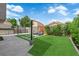 Backyard boasts a synthetic lawn, concrete patio, pergola, desert landscaping, and cozy lounge seating at 21 Rue De Degas, Henderson, NV 89074