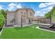 Back exterior of home featuring synthetic grass, patio, pergola, lounge chairs, and desert landscaping at 21 Rue De Degas, Henderson, NV 89074