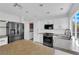 Modern white kitchen featuring stainless steel appliances, an island, and updated fixtures at 21 Rue De Degas, Henderson, NV 89074
