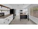 Modern white kitchen with black stainless appliances, an island, and a tile backsplash at 21 Rue De Degas, Henderson, NV 89074