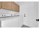 Efficient laundry room featuring side-by-side washer and dryer units and upper cabinet storage at 21 Rue De Degas, Henderson, NV 89074