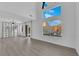 Bright living room featuring gray wood floors, modern lighting, and a high ceiling at 21 Rue De Degas, Henderson, NV 89074